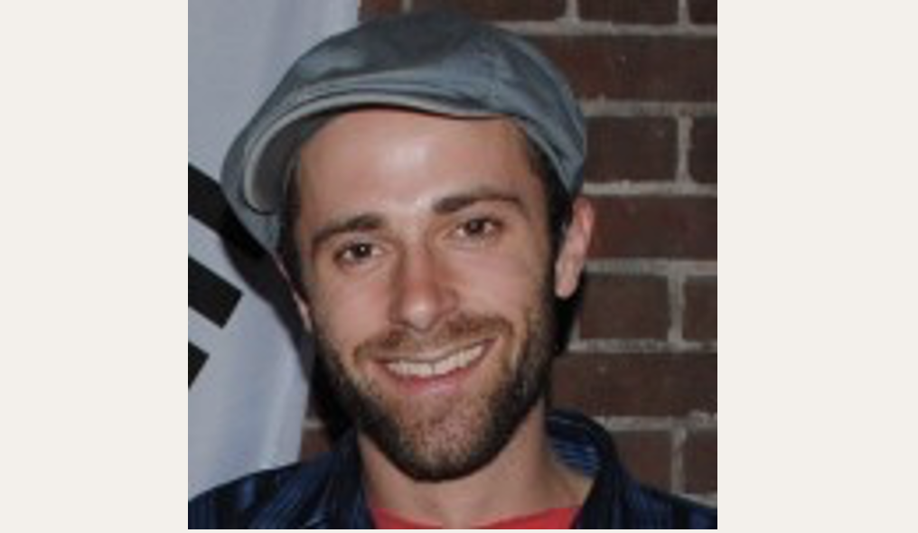 Stephen wearing hat against brick background