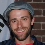 Stephen wearing hat against brick background
